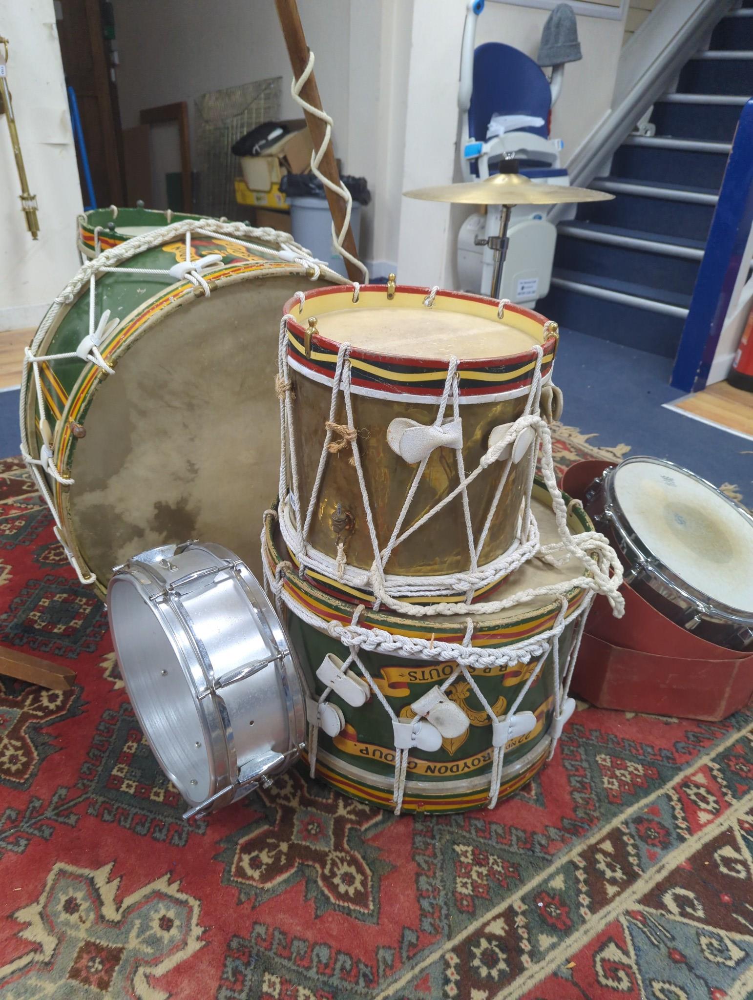 A collection of painted wood drums from Warningham troop, probably ex. military, together with leather straps sheet music pouches, a pre 1947 leopard skin for the bass drum (lined), drum major's jacket and staff, cymbals